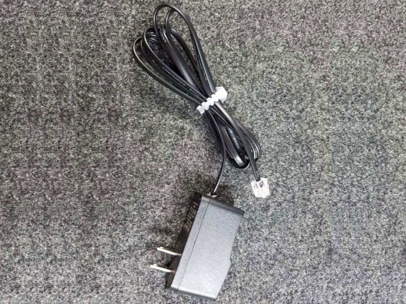 Black AC adapter with telephone-style connector